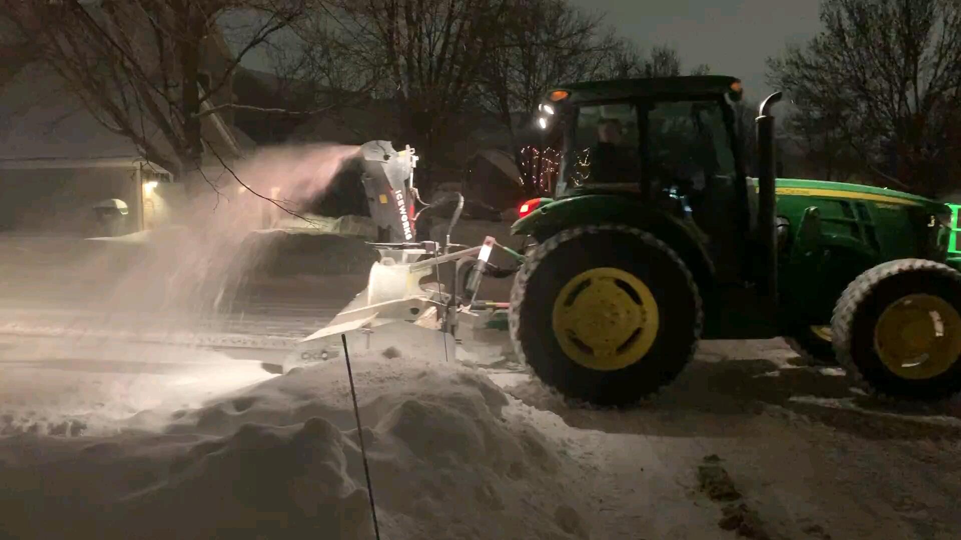 The ridge of packed snow a city plow leaves across the end of a driveway